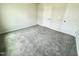 A bright bedroom featuring neutral walls, soft gray carpet, and minimalist white door and trim at 138 Sourgum Ct, Zebulon, NC 27597