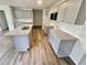 Well-equipped kitchen boasting granite countertops, gray cabinets, and wood flooring at 138 Sourgum Ct, Zebulon, NC 27597