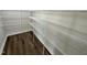 Walk-in pantry with multiple shelves and wood-look floors at 138 Sourgum Ct, Zebulon, NC 27597