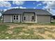 The rear exterior of the home shows horizontal siding and windows looking out onto the back yard at 138 Sourgum Ct, Zebulon, NC 27597