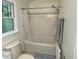 Bathroom featuring a tub with shower, a window, and decorative tiling at 14 Striding Ridge Ct, Durham, NC 27713