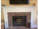 Living room featuring a brick fireplace with white mantle and flatscreen television above at 14 Striding Ridge Ct, Durham, NC 27713