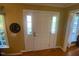 Bright entryway featuring a white front door with sidelights and natural light, complemented by a decorative mirror at 14 Striding Ridge Ct, Durham, NC 27713