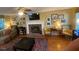 Living room with a brick fireplace, ceiling fan, hardwood floors, and lots of wall art at 14 Striding Ridge Ct, Durham, NC 27713