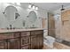 Bathroom featuring double sink, granite countertop, oval mirrors and a glass enclosed shower at 148 Shadowbrook Dr, Henderson, NC 27537