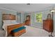 Spacious bedroom with classic wooden furniture, plush carpet and a bright sunny window at 148 Shadowbrook Dr, Henderson, NC 27537