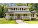 Charming two-story home featuring a welcoming front porch, black shutters, and a well-maintained lawn at 148 Shadowbrook Dr, Henderson, NC 27537