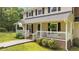 Inviting front porch with a swing, landscaping, and neutral siding showcasing a cozy curb appeal at 148 Shadowbrook Dr, Henderson, NC 27537