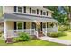 Charming home featuring a cozy front porch, lush landscaping, and classic architectural details at 148 Shadowbrook Dr, Henderson, NC 27537