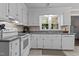 Bright kitchen featuring white cabinets, tile flooring, and granite countertops, complete with modern appliances and ample natural light at 148 Shadowbrook Dr, Henderson, NC 27537