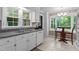 Charming kitchen with granite countertops, white cabinets, and a breakfast nook with large window overlooking the yard at 148 Shadowbrook Dr, Henderson, NC 27537