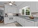 Well-lit kitchen with granite countertops, white appliances, tile flooring, and ample cabinet space for storage and functionality at 148 Shadowbrook Dr, Henderson, NC 27537