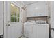 Practical laundry room with washer, dryer, utility sink, and storage cabinets, providing convenience and functionality at 148 Shadowbrook Dr, Henderson, NC 27537
