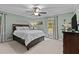 Light and airy main bedroom with a ceiling fan, dark wood furnishings and a large bed at 148 Shadowbrook Dr, Henderson, NC 27537