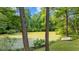 Backyard pond with small rowboat and lush green surroundings at 148 Shadowbrook Dr, Henderson, NC 27537