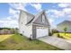 Exterior view of a two-story home featuring gray and white siding, an attached two-car garage, and a green lawn at 152 Briar Den Ct, Benson, NC 27504