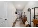 Hallway featuring neutral-colored walls, wood-look flooring, doors, and decor including photo frames at 152 Briar Den Ct, Benson, NC 27504