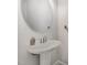 A simple powder room with a pedestal sink and oval mirror creates a clean aesthetic at 152 Briar Den Ct, Benson, NC 27504