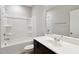 Clean bathroom with a dark vanity, white sink, tub, and a white shower at 1600 Tinos Overlook Way, Apex, NC 27502