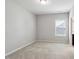 Cozy bedroom with a large window and neutral carpeting, ideal for relaxation at 1600 Tinos Overlook Way, Apex, NC 27502
