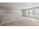 Bright bonus room with neutral walls, carpeted floors, and natural light from multiple windows at 1600 Tinos Overlook Way, Apex, NC 27502