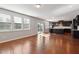 Open-concept living room with hardwood floors flowing into a kitchen with dark cabinets and an island at 1600 Tinos Overlook Way, Apex, NC 27502