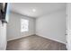 A bedroom features laminated floors, a window, and a wall-mounted television at 165 Bywood Dr, Roxboro, NC 27573