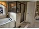 Bathroom featuring a tub, glass shower and neutral earth tone tile at 1655 Kingfisher Ct, Nashville, NC 27856
