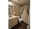 Cozy bathroom with vanity, toilet, floral shower curtain, and wood tile floor at 1655 Kingfisher Ct, Nashville, NC 27856