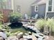 Peaceful fenced-in backyard featuring a small pond, lush landscaping, and outdoor seating at 1707 Falls Church Rd, Raleigh, NC 27609