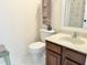 Bright bathroom with tile flooring featuring a toilet, sink with vanity, and towel racks at 1707 Falls Church Rd, Raleigh, NC 27609