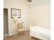 Bright bedroom with neutral walls featuring a twin bed, comfy chair, and interior door at 1707 Falls Church Rd, Raleigh, NC 27609