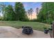 Patio and backyard area featuring a decorative fire pit and beautiful trees at 175 Lockamy Ln, Youngsville, NC 27596