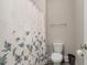 Clean bathroom featuring a floral patterned shower curtain, toilet, and white fixtures at 175 Lockamy Ln, Youngsville, NC 27596
