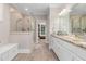 Bright bathroom featuring a glass shower, double sink vanity with granite countertop, and wood-look tile floor at 175 Lockamy Ln, Youngsville, NC 27596