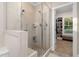 Bright bathroom featuring a glass shower with a built-in bench and a view into the spacious walk-in closet at 175 Lockamy Ln, Youngsville, NC 27596