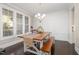 Well-lit dining room with large windows, a wooden table and white chairs, and modern decor at 175 Lockamy Ln, Youngsville, NC 27596