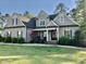 Charming single-Gathering home with a covered front porch, lush landscaping, and an American flag at 175 Lockamy Ln, Youngsville, NC 27596