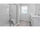 Modern bathroom featuring a glass-enclosed shower, double sinks, and neutral tile flooring at 1907 Hinesley Dr, Durham, NC 27703