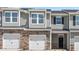 Row of new townhomes featuring stone accents, attached garages, and a modern design at 1907 Hinesley Dr, Durham, NC 27703
