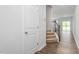 Inviting hallway with hardwood floors, staircase with dark banister, and natural light at 1913 Hinesley Dr, Durham, NC 27703