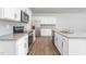 A modern kitchen with stainless steel appliances, granite countertops, tile backsplash, and white cabinets at 1913 Hinesley Dr, Durham, NC 27703
