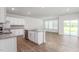 Open kitchen and living area, featuring an island, white cabinets, stainless steel appliances, and hardwood floors at 1913 Hinesley Dr, Durham, NC 27703
