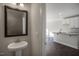 Stylish powder room with a pedestal sink, decorative mirror, and view to kitchen at 1915 Hinesley Dr, Durham, NC 27703