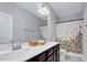 Well-lit bathroom features a double sink vanity with modern fixtures and a shower-tub combination with floral shower curtain at 200 Chateau Way, Angier, NC 27501