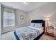 Cozy bedroom with blue accents featuring a window and side table with lamp at 200 Chateau Way, Angier, NC 27501