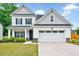 Charming two-story home featuring a well-manicured lawn, covered porch, and a two-car garage at 200 Chateau Way, Angier, NC 27501