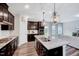 Stylish kitchen with granite countertops, dark cabinets, and an island with a sink at 200 Chateau Way, Angier, NC 27501