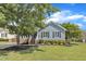 Charming blue home featuring a well-manicured lawn, mature tree, and welcoming brick stairs at 2006 Keokuk Ct, Apex, NC 27523