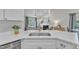 Bright kitchen featuring white cabinets, subway tile backsplash, quartz countertops, and stainless steel sink at 2006 Keokuk Ct, Apex, NC 27523